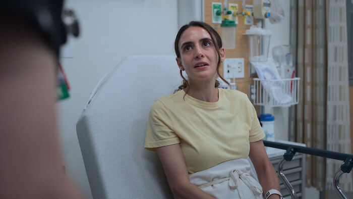 Young woman in hospital bed, discussing concerns about MRSA and hospital-acquired infections with medical staff. - 2