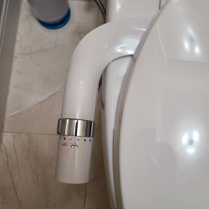 Close-up of a bidet attachment on a toilet, showcasing a common European bathroom practice that may seem unusual in the US.