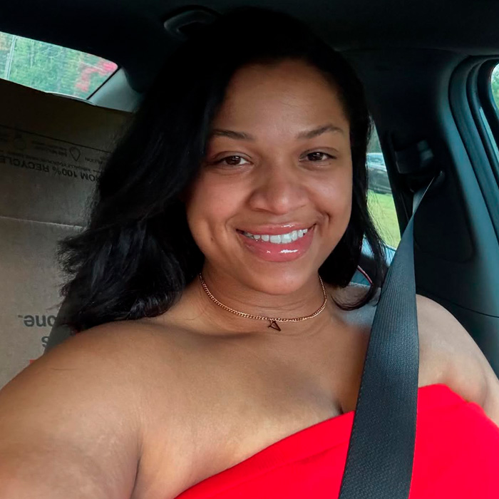 TikTok influencer smiling in car wearing red top and seatbelt after admitting inappropriate act in couple&rsquo;s home.