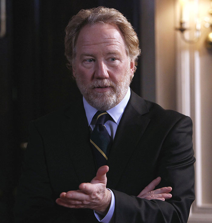 Middle-aged man in a suit with a beard gesturing, related to Timothy Busfield case and audio denying claims of crimes.