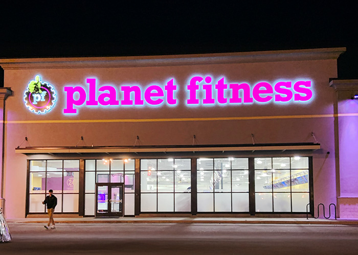 Planet Fitness storefront at night with neon sign, related to transphobic bathroom incident and locker room policies debate. Planet Fitness storefront at night with neon sign, related to transphobic bathroom incident and locker room policies debate.