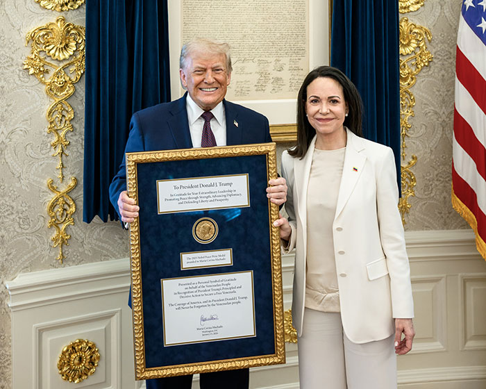 Former President Trump holding framed Nobel Peace Prize medal gifted by recipient, with Nobel Committee response following the event.