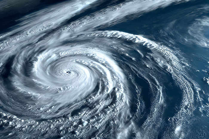 Satellite image of a massive swirling storm over the ocean, evoking unexplainable natural phenomena seen from space.