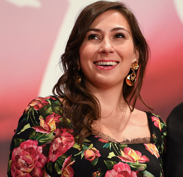 Woman with long brown hair wearing floral dress and gold earrings, related to Tommy Lee Jones's daughter hotel case in San Francisco.