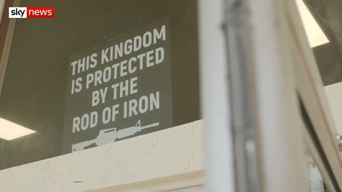Sign reading this kingdom is protected by the rod of iron, highlighting bizarre lesser-known facts about these countries.