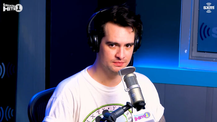 Radio host wearing headphones and speaking into a microphone during a live discussion about meeting idols in real life.