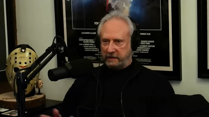 Man with headphones and microphone speaking in a podcast studio about people meeting their idols and regretting it.