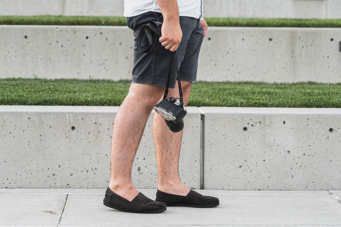 Person in shorts holding a camera, illustrating moments when women's attraction ends due to a weird ick they got.