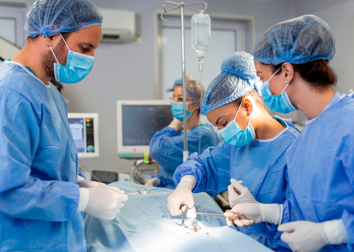 Surgeons performing a procedure in an operating room, illustrating the use of donated lifeless bodies for BBLs and breast implants. Surgeons performing a procedure in an operating room, illustrating the use of donated lifeless bodies for BBLs and breast implants.