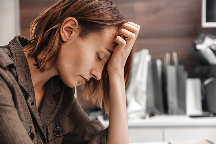 Woman looking stressed and frustrated while sitting indoors, reflecting annoyance about her SIL situation. Woman looking stressed and frustrated while sitting indoors, reflecting annoyance about her SIL situation.