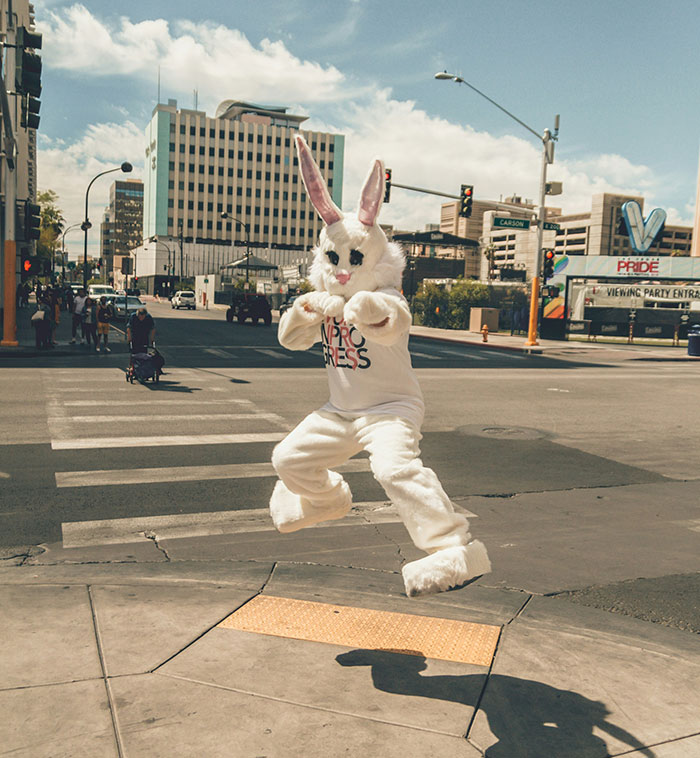 Person in a white bunny costume jumping mid-air on a city street, capturing a weird moment people witnessed.