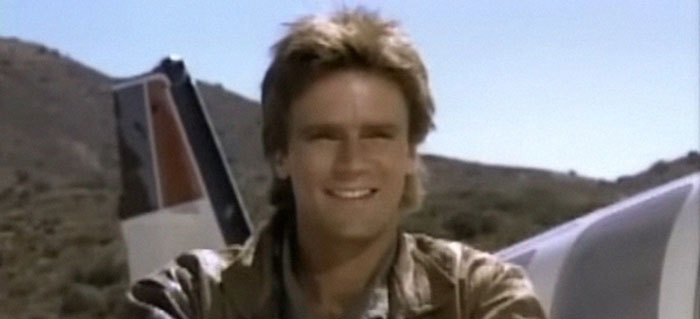 Smiling man standing outdoors near aircraft with hills in background, a moment people witnessed something weird.