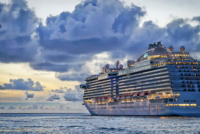 Large cruise ship at sea during sunset with dramatic clouds, capturing a weird and unexplained moment witnessed by people.