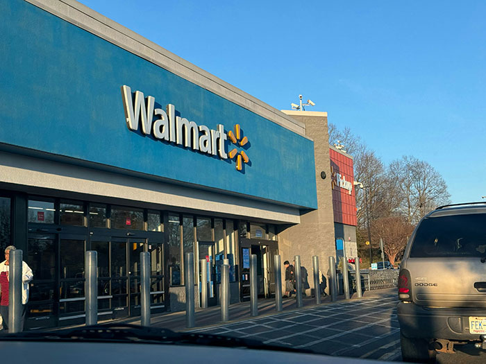 Walmart store entrance with people outside and cars parked, capturing a moment of something weird witnessed.