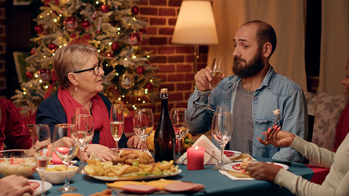 Woman appalled by chauvinist brother and gaslighting mom, family drama at holiday dinner table.