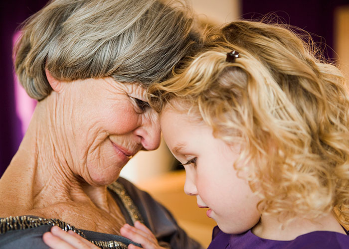 Older woman with child, showing close bond and care, reflecting feelings of being an unpaid nanny after partner leaves.