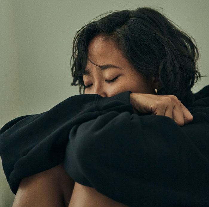 Stressed mom of 6 sitting with eyes closed, overwhelmed while babysitting her brother&rsquo;s son, feeling emotionally drained.