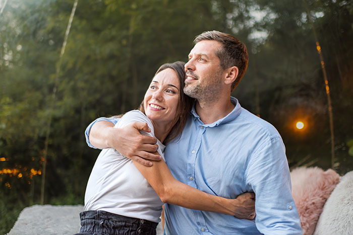 Couple embracing outdoors with the woman smiling, illustrating a mistaken mistress in a four-year relationship.