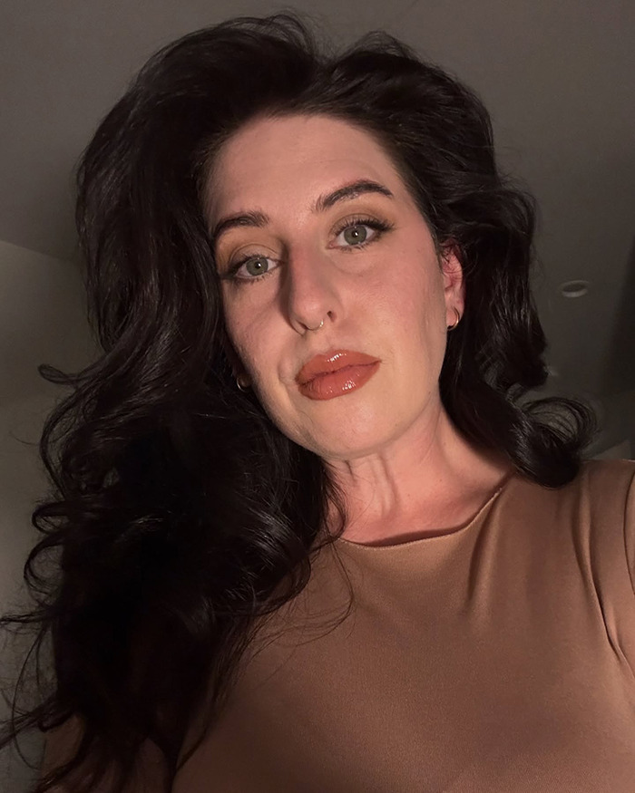 Single woman with dark hair and neutral makeup looking surprised after matching with perfect guy on Hinge app.