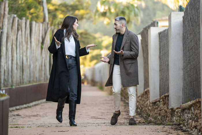 Woman and man having a serious outdoor conversation, addressing common misconceptions about women in modern times.