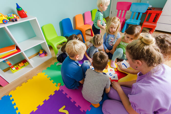 Teacher engaging children in a colorful classroom, challenging misconceptions about women and promoting modern understanding.