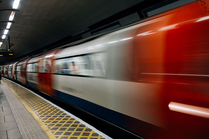 Blurred subway train speeding past an empty platform, illustrating lucky times people escaped dangerous situations.