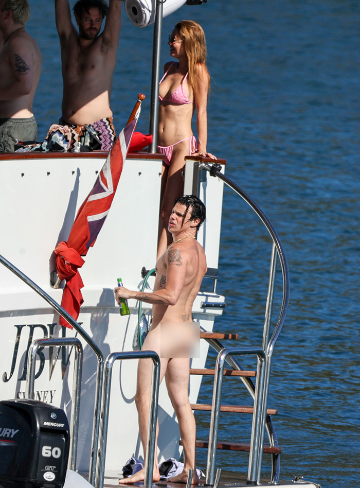 Unclothed rock star Yungblud holding a drink on a yacht with other partygoers during a wild Sydney yacht bash. Unclothed rock star Yungblud holding a drink on a yacht with other partygoers during a wild Sydney yacht bash.