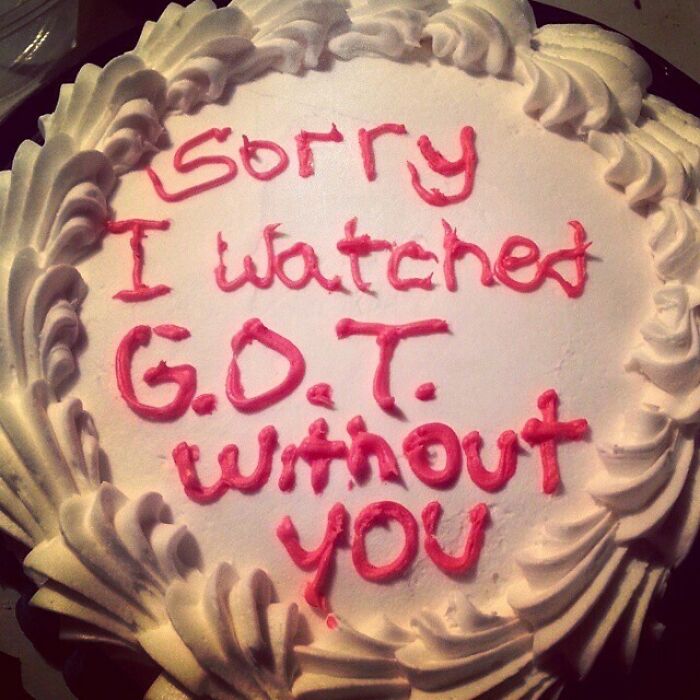 Round white cake with pink icing text saying Sorry I watched G.O.T. without you, a funny cake reflecting honest emotions.
