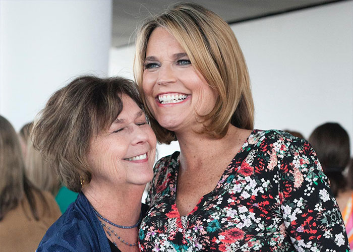 Two women smiling and embracing indoors, with a hostage negotiator theory and helicopter filmed above Nancy Guthrie's house.