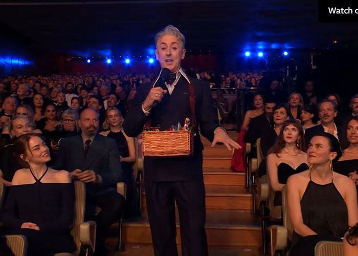 Host speaking to audience at the 2026 BAFTAs, fans spot major detail in Kylie Jenner's lip appearance.