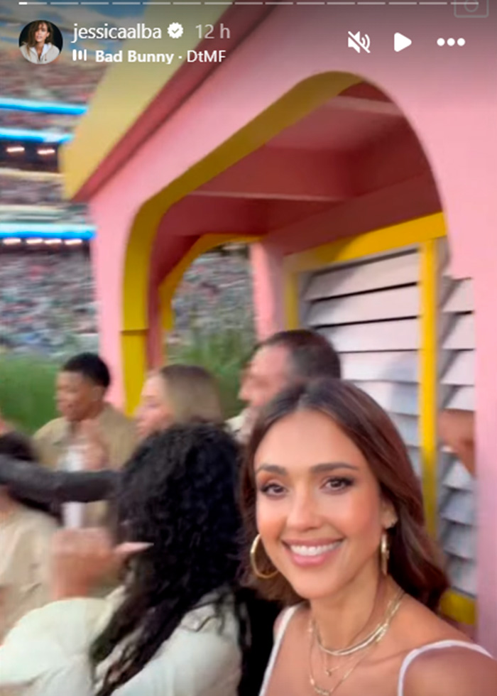 Jessica Alba smiling and dancing with a group of people during the Super Bowl halftime show performance.