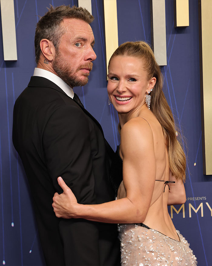 Dax Shepard and Kristen Bell posing together on the red carpet, dressed elegantly for an event.