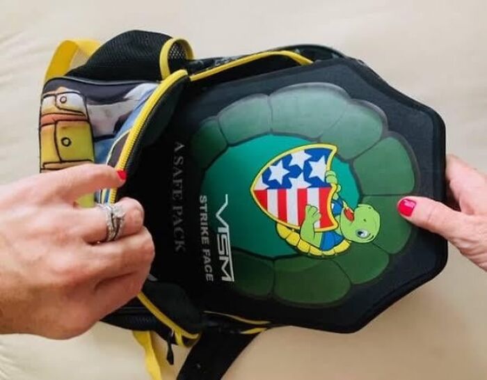 Turtle-themed protective gear inside a backpack, illustrating a unique dystopian nightmare safety concept.