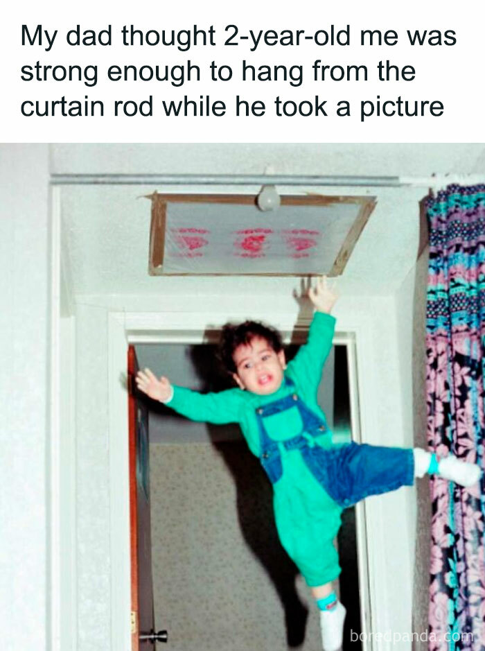 Toddler hanging from curtain rod with one hand, captured in an entertaining and unhinged random meme moment.