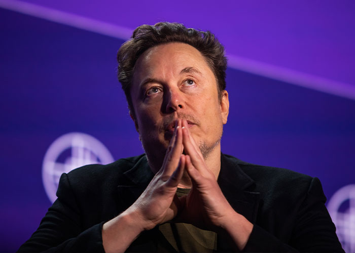 Elon Musk in deep thought with hands clasped, sparking theories about something really bad coming soon.