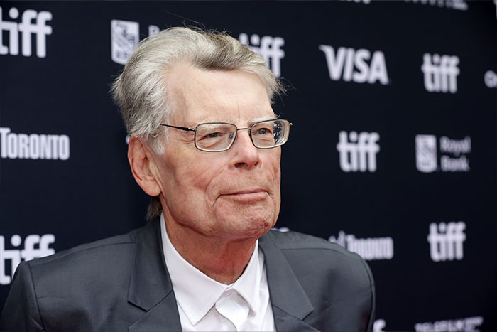 Stephen King at Toronto Film Festival wearing glasses and suit amid backlash over claim about Donald Trump.