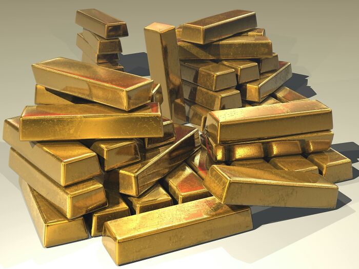 Stacks of shiny gold bars piled together, illustrating wealth for the Would You Still Do It Poll concept.