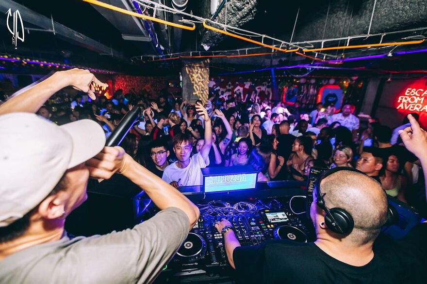 DJ and crowd enjoying a lively nightlife party in one of the cities where sleep is optional worldwide.