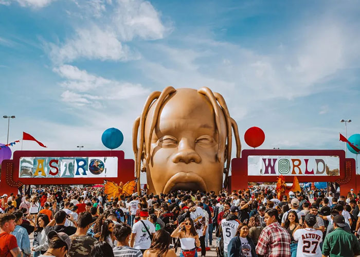 Crowd gathered around large Travis Scott Astroworld head installation at an event, highlighting controversial kids party theme reaction.