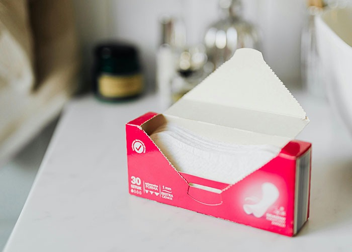 Box of sanitary pads on a countertop illustrating practical items countries have that just make sense and others should note.