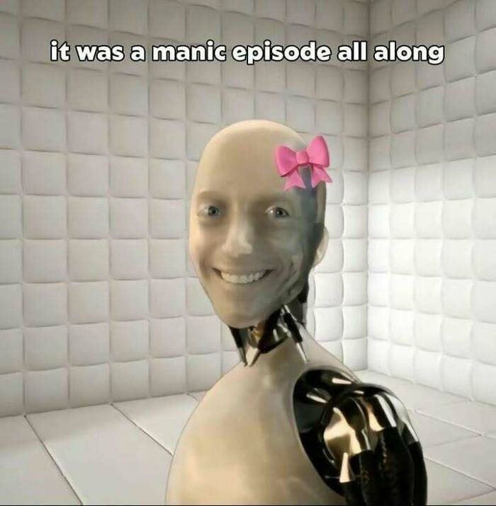 Smiling robot with a pink bow in a padded white room, captioned with a manic episode text in hilarious memes.