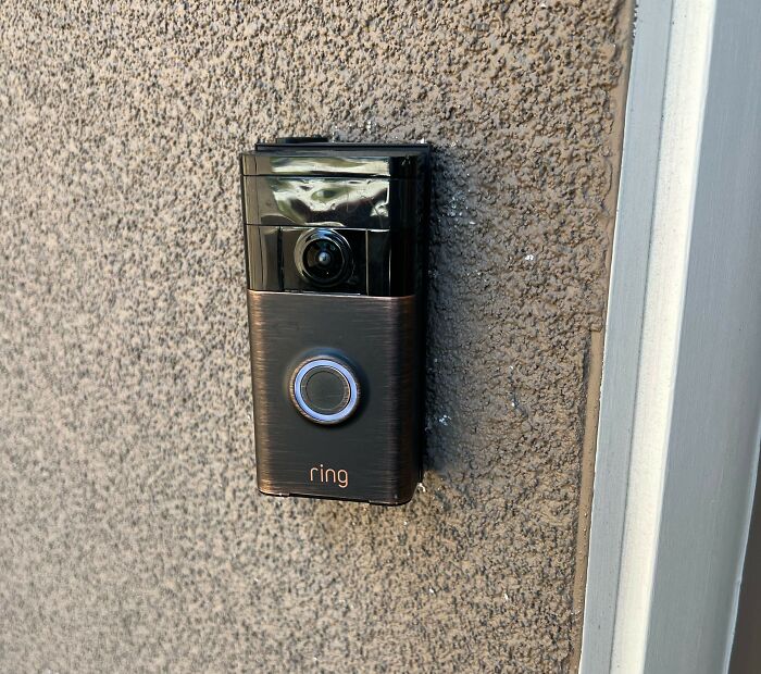 Smart video doorbell mounted on textured wall capturing footage as a brutal wake-up call for safety awareness.