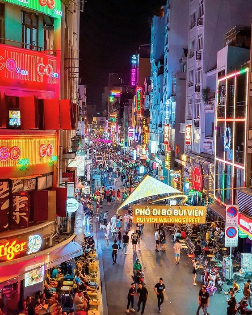 Bui Vien Walking Street at night bustling with crowds and colorful neon signs in a city where sleep is optional
