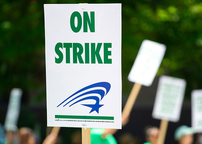 Protesters holding signs on strike representing one of the things countries have that just make sense.