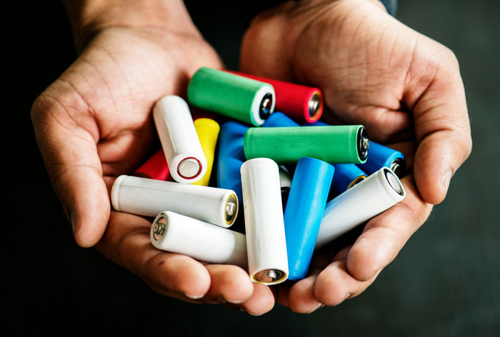 Close-up of hands holding assorted colorful batteries representing healthcare workers' experiences and insights after what they've seen.