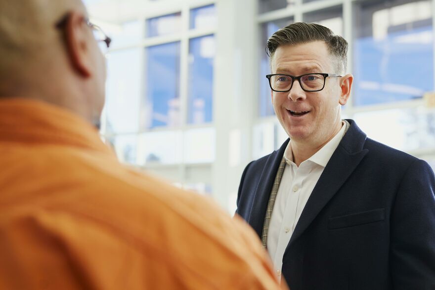 Two men having a lively conversation indoors, illustrating common social pet peeves that divide a room instantly.