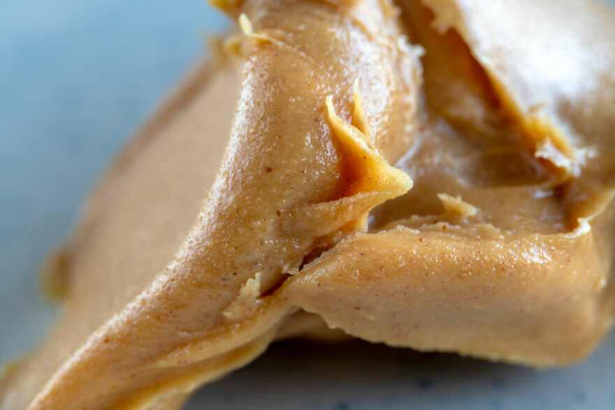 Close-up of creamy peanut butter texture, illustrating a common pet peeve that can instantly divide a room.