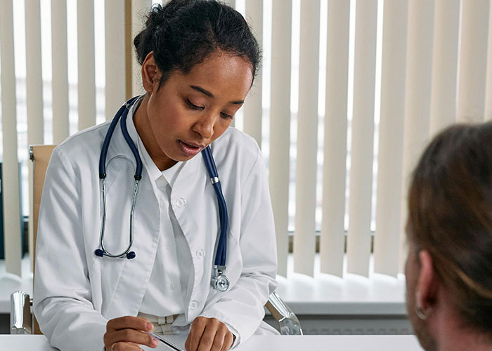 Doctor in white coat with stethoscope consulting patient, illustrating things countries have that just make sense concept