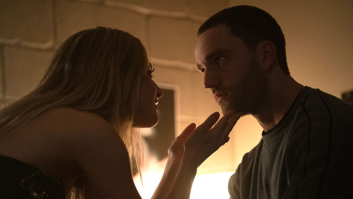 A man and woman share an intimate moment in dim light, relating to Tell Me Lies season 4 and the show's fate discussion.