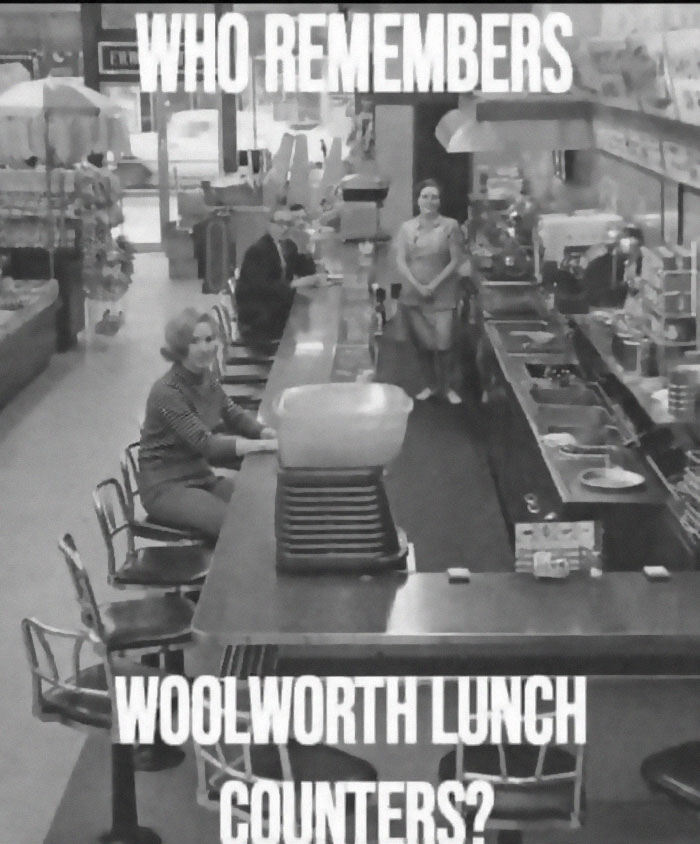 Black and white nostalgic photo of Woolworth lunch counter with people sitting and standing inside the store.